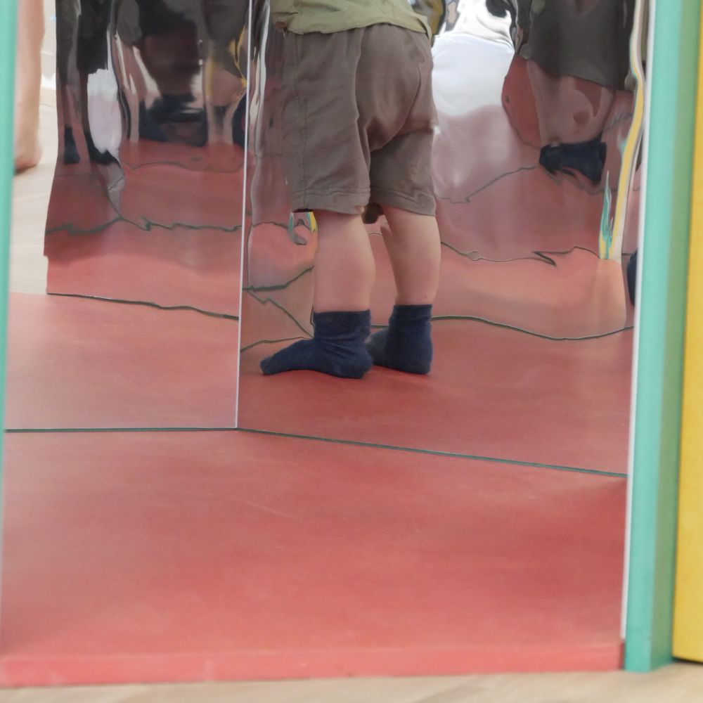 Jambes d'enfant dans la cabane a miroirs infinis
