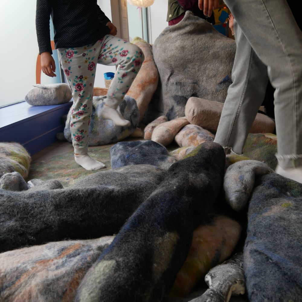 enfants qui grimpent sur les rochers d'amine benttabou en feutre laine naturel au musée des mômes