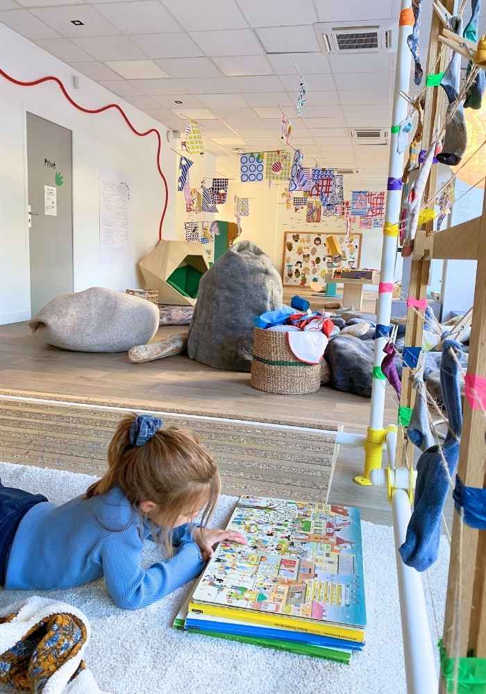 une enfant qui lit un livre dans la cabane à chaussettes orphelines